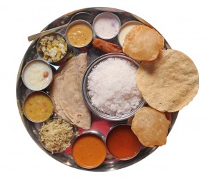 Traditional indian lunch food and meals with rice, phulka, puri, curries and sweets isolated on white